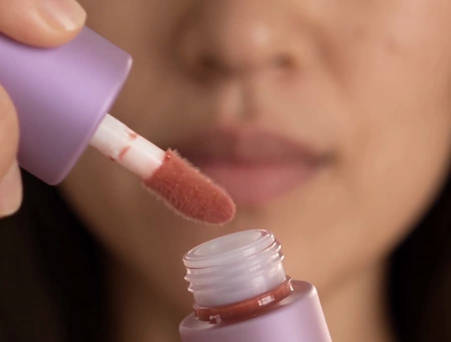 A digital model trying on lip gloss